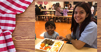 Student eating lunch with adult