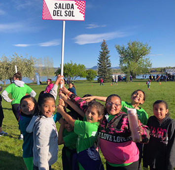 Students on field holding sign