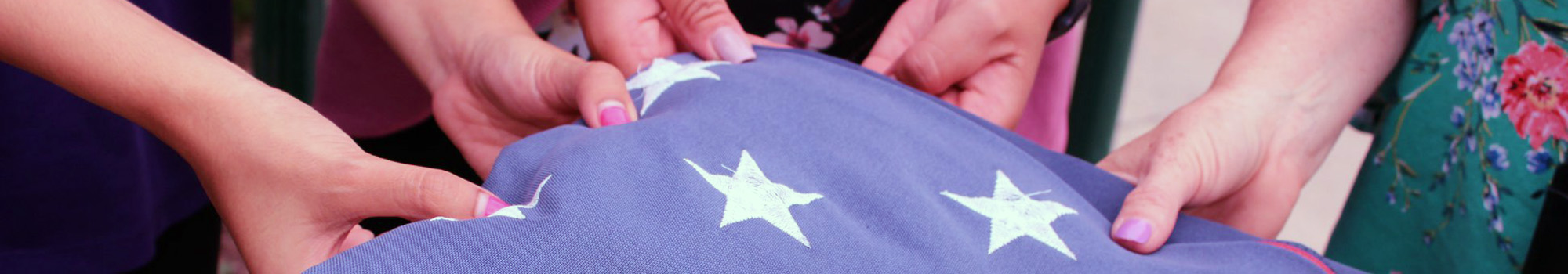 Close up photo of teachers folding United States flag