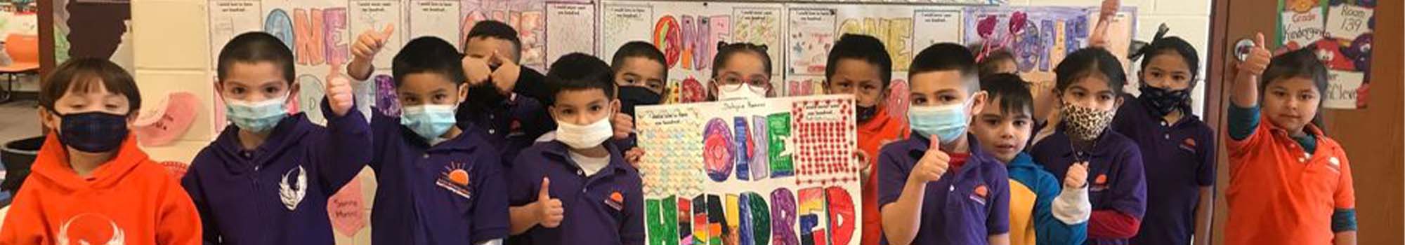 group of kids with 100 days of school poster