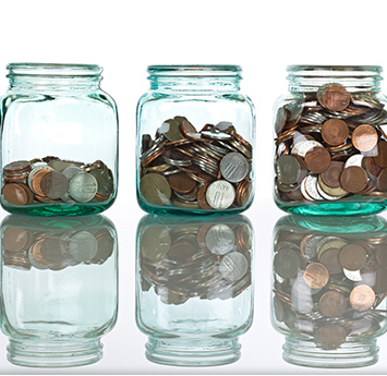 Three glass jars filled with coins