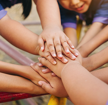 Group of diverse kids stacking their hands