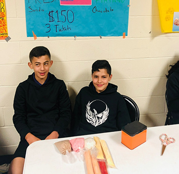 Two happy middle school boys sitting at a table