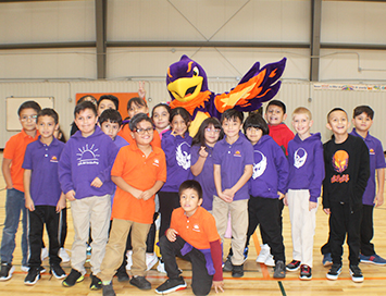 Group of happy elementary students with school mascot