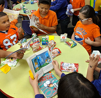 Group of happy students reading at a table